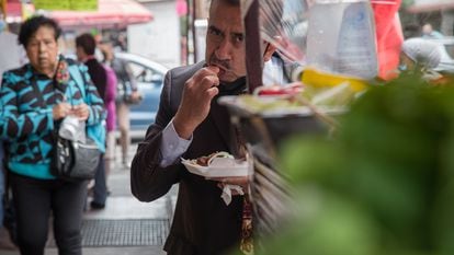 A man eats tacos at a Mexico City street stall in 2021.