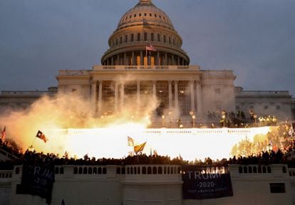 An explosion caused by a police munition is seen while supporters of former president Donald Trump riot in front of the U.S. Capitol in Washington on January 6, 2021.