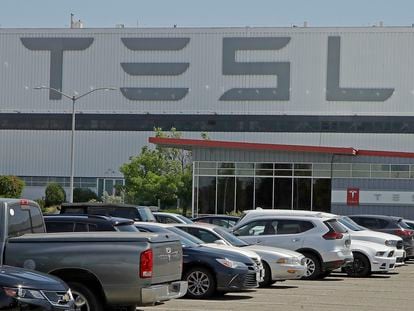 A man walks in the Tesla plant parking lot