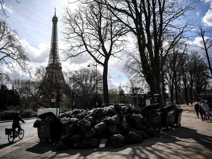 Pedestrians and cyclists walk past a mountain of trash near the Eiffel Tower on Wednesday.