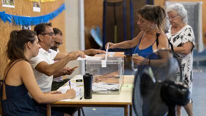 A woman votes in a Barcelona polling station equipped with multiple fans, this Sunday.