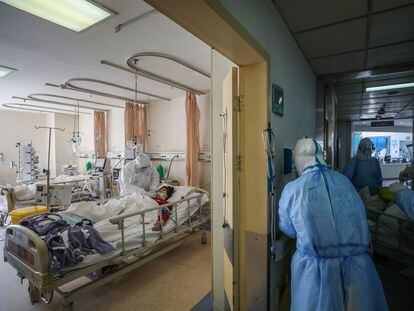 Healthcare workers attend to a Covid-19 patient in an isolation ward of a hospital in Wuhan, China, February 2020.