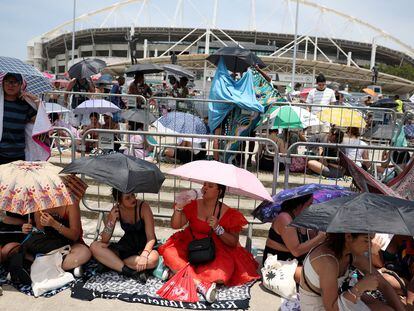 People holding umbrellas wait for the Taylor Swift concert, following the death of a fan due to the heat during the first day concert, in Rio de Janeiro, Brazil, November 18, 2023.