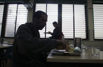 A man prepares to eat his rations in a charity canteen.