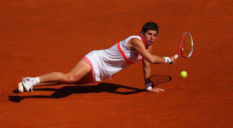 Carla Suárez stretches to return the ball to Samantha Stosur on Monday.