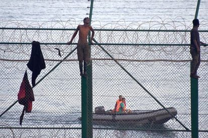 Migrants jump the border fence into Ceuta.