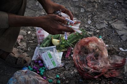 Un drogadicto llega a la colina de Sarai Shamali de Kabul, donde viven cientos de drogadictos, con material ensangrentado recuperado de la basura de un hospital para reutilizarlo en el consumo de drogas.