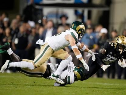 Colorado cornerback Travis Hunter (12) is dragged down by Colorado State defensive back Henry Blackburn, back left, and defensive back Ayden Hector during the first half of an NCAA college football game Saturday, Sept. 16, 2023, in Boulder, Colo.