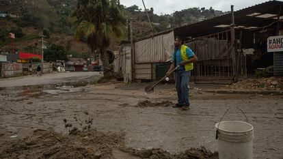 José Guzmán cleans up mud in the streets of Los Laureles in Tijuana after a night of rain; November 15, 2023.