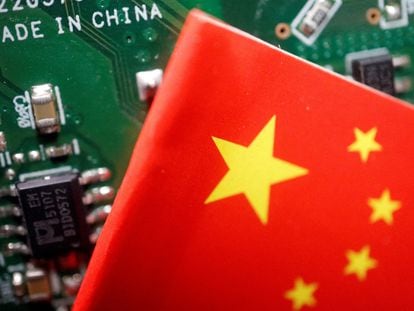 A Chinese flag is displayed next to a 'Made in China' sign seen on a printed circuit board with semiconductor chips, in this illustration picture taken February 17, 2023.