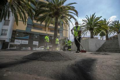 A cleaning crew sent from Tenerife clears the ash from a square in Los Llanos.