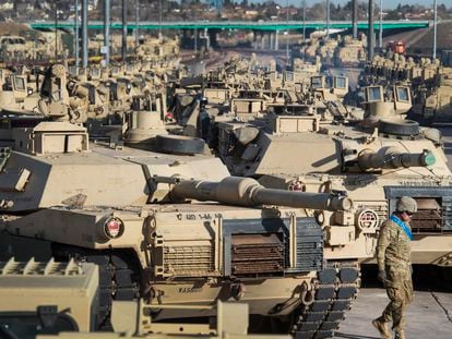 A soldier walks past a line of M1 Abrams tanks, Nov. 29, 2016, at Fort Carson in Colorado Springs, Colo.
