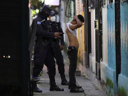 A police officer searches a man living in the Kiwanis Community, during a preventive patrol in search of gang members in Soyapango, El Salvador.
