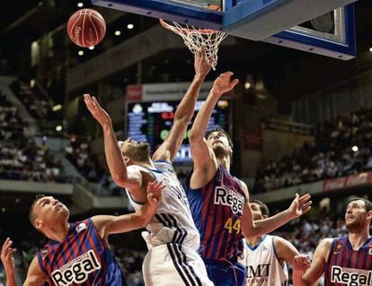 Real Madrid captain Felipe Reyes fights for a rebound with Bar&ccedil;a&#039;s Sarunas Jasikevicius and Ante Tomic.