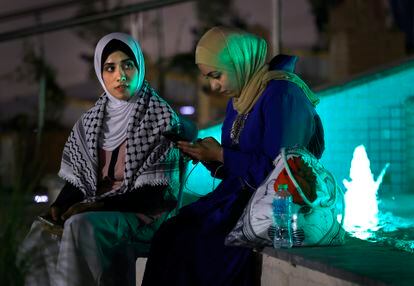 Two women wait for the inaugural game of the 2022 World Cup to end, outside the Al Bayt stadium in Doha. Mexico and Qatar played the first match.