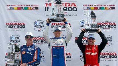 Winner Alex Palou, center, second-place finisher Scott Dixon, left, and third-place finisher Will Power, right, raise their trophies in Victory Lane after an IndyCar auto race at Mid-Ohio Sports Car Course in Lexington, Ohio, Sunday, July 2, 2023.
