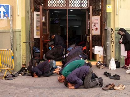 The Muslim faithful pray at the doors of Baitul Mukarram mosque in Lavapiés, Madrid.