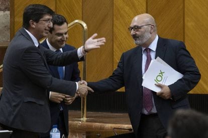 The premier of Andalusia, Juan Manuel Moreno Bonilla (c), and the deputy permier Juan Marín (l), shake hands with Vox regional spokesperson Alejandro Hernández.