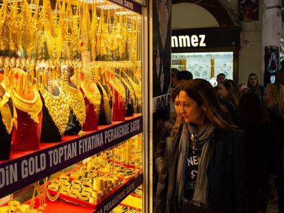 Several women walk past a window display with gold jewelry in Istanbul's Grand Bazaar.