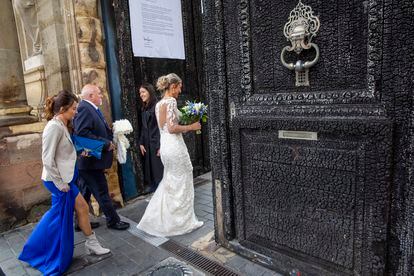 A bride passing through the charred door of Bordeaux City Hall on Friday.