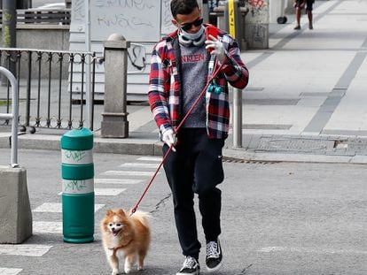 A man walking his dog in Madrid. Animal societies have asked owners to take their pets out on short walks during the lockdown. 
