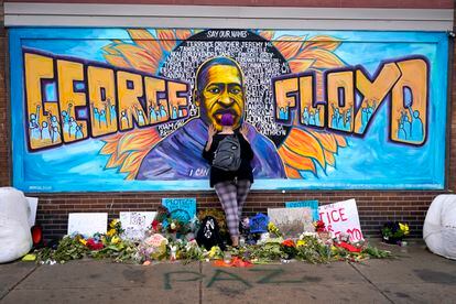 Damarra Atkins pays respect to George Floyd at a mural at George Floyd Square in Minneapolis