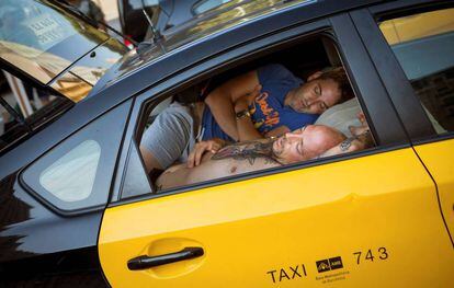 Two drivers sleep in a taxi in Barcelona.