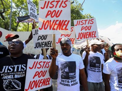Demonstrators hold signs reading 'Justice for Jovenel' outside a judicial hearing into the assassination of President Jovenel Moise attended by former first lady Martine Moise, in Port-au-Prince, Haiti October 6, 2021.