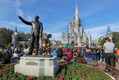 In this Jan. 9, 2019 photo, guests watch a show near a statue of Walt Disney and Micky Mouse in front of the Cinderella Castle at the Magic Kingdom at Walt Disney World in Lake Buena Vista, Fla.