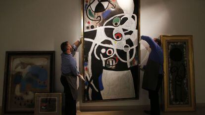 Christie&acute;s auction house workers adjust one of the paintings by Joan Mir&oacute; which Portugal&#039;s government hopes to sell.