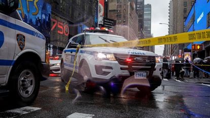 Patrol cars from the New York Police Department block a street next to a crime scene.
