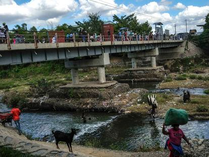 People bathe in the Massacre River, named for a bloody battle between Spanish and French colonizers in the 1700s, on the border with Haiti in Ouanaminthe, Dominican Republic, Nov. 19, 2021.