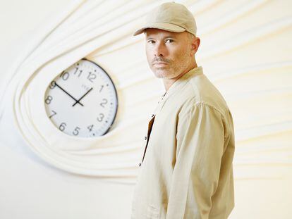 Daniel Arsham, pictured in the Perrotin art gallery, in Paris, near his work 'Falling Clock' (2023)