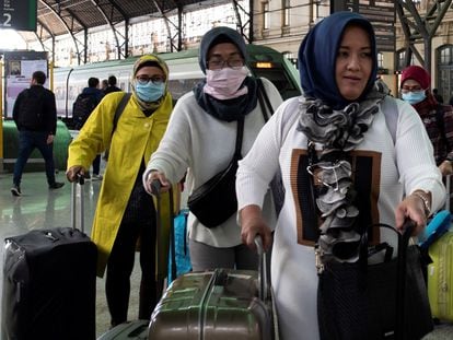 Tourists with face masks arrive at the train station in Valencia.