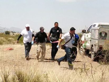 Authorities carry the body of six-year-old Christopher who was killed on the outskirts of Chihuahua.