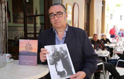 Joaquín García de Romeu holds a photo of Cándida next to his book, ‘The Last Black Woman.’