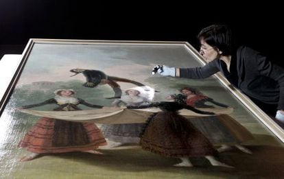 A conservationist inspects the Goya painting El Pelele before it was hung for the CaixaForum exhibition in Barcelona. 