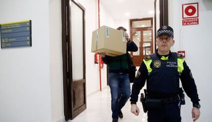 An investigator takes away a box from Popular Party offices in Valencia on Tuesday.