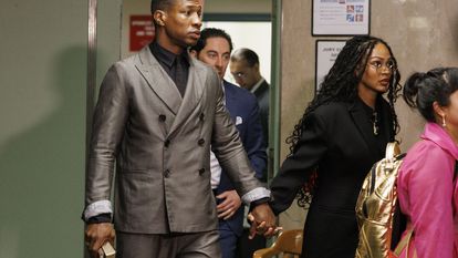 Actors Jonathan Majors and Meagan Good hold hands as they enter the courtroom in New York, New York, on December 18, 2023.