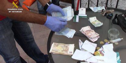 A Civil Guard officer counts the money seized from the drug ring.