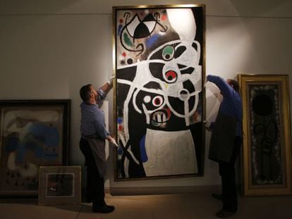 Christie&acute;s auction house workers adjust one of the paintings by Joan Mir&oacute; which Portugal&#039;s government hopes to sell.