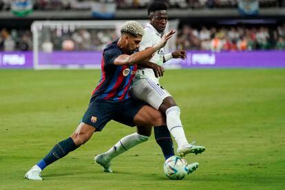 Barcelona's Araujo, left, and Real Madrid's Vinicius Jr. battle for the ball during the first half of a friendly soccer match in Las Vegas, Saturday, July 23, 2022.