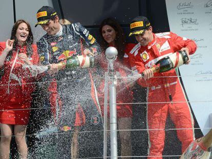 Red Bull&#039;s Mark Webber and Ferrari&#039;s Fernando Alonso spray champagne on the podium at the Silverstone circuit after the British Grand Prix.  