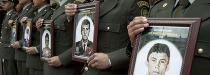 Police officers in Colombia hold photographs of their fellow officers who were kidapped by the FARC. 