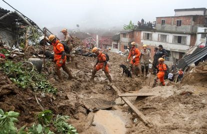 Rescue workers walk at a site of a mudslide at Morro da Oficina in Petropolis.