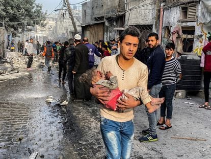 A young man carries a girl who was the victim of a bombing in Rafah, in southern Gaza, December 1.
