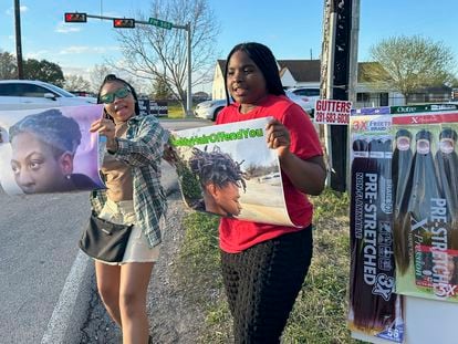 Shan'Terrius Sly-Brown, 16, left, and Shaniya Wade-Red, 15, hold signs during a protest outside of the home of Barbers Hill Independent School District superintendent, Feb. 21, 2024 in Baytown, Texas.