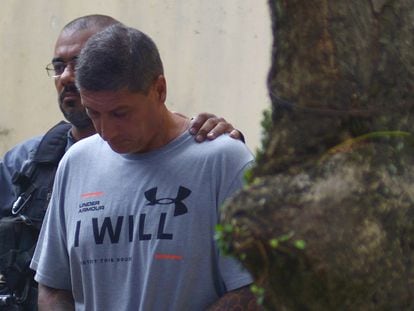 Ronnie Lessa is escorted by a police officer after testifying at the homicide department in Rio de Janeiro, in 2019.