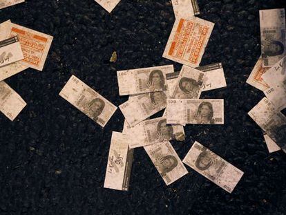 Fake 100-peso bills with a picture of President Cristina Fern&aacute;ndez de Kirchner lie on the ground after a protest outside Congress.