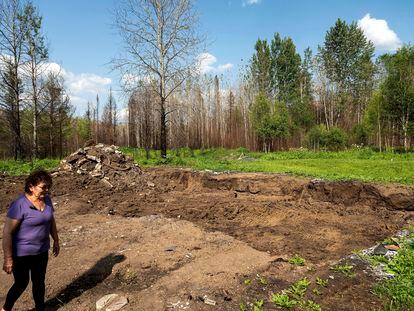 Carrol Johnston passes an indentation where her home stood before a May wildfire destroyed it in the East Prairie Metis Settlement, Alberta, on Tuesday, July 4, 2023.